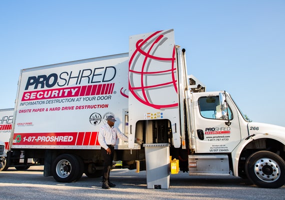 PROSHRED mobile truck being loaded with a bin of materials to be shredded.