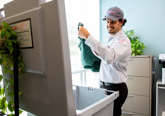 man emptying a shredding bin