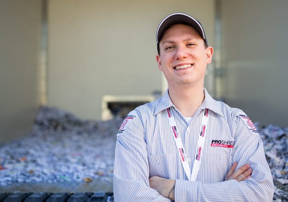 Product destruction professional standing in front of a warehouse.