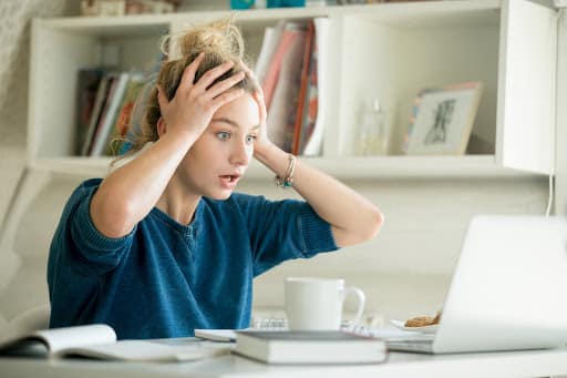 a woman appearing stressed and putting her hands to her head