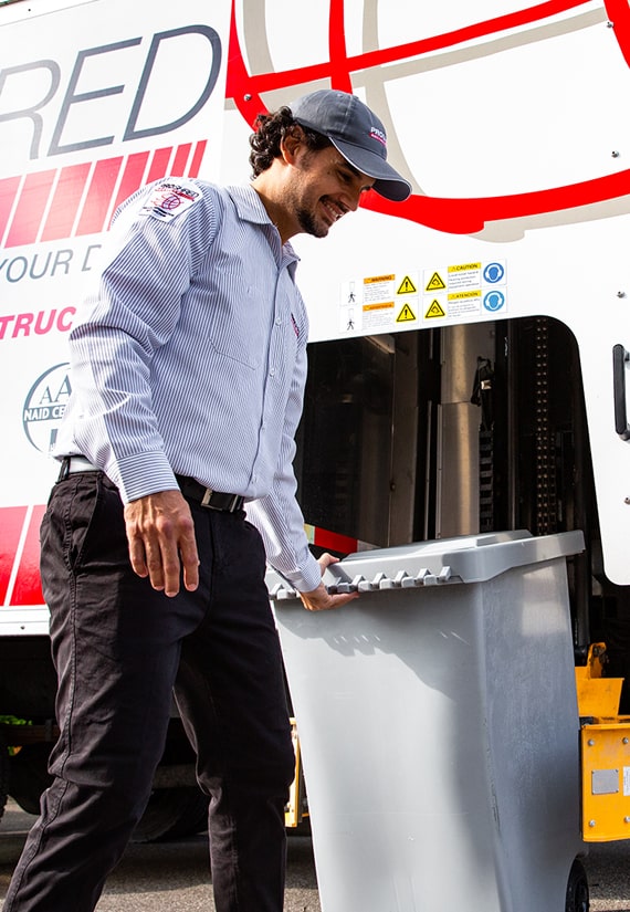 PROSHRED employee uploading shredding bin to mobile shredding truck.