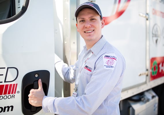 PROSHRED employee smiling and opening a mobile shredding truck door.