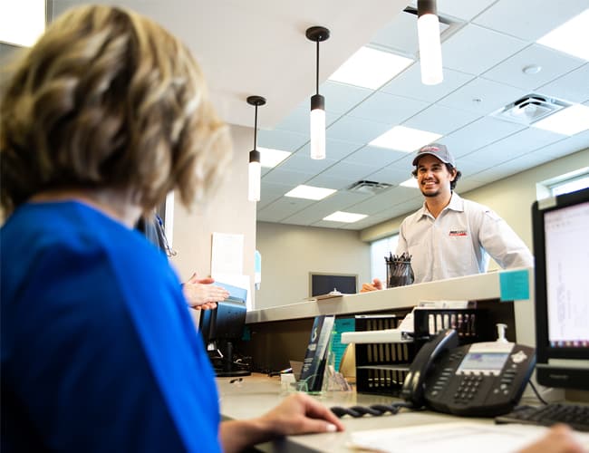 Receptionist at an office greeting a Proshred employee.