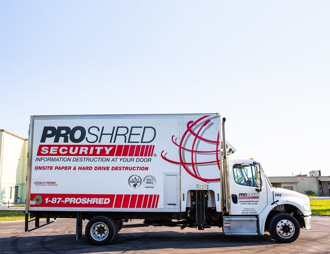 PROSHRED mobile document shredding truck parked outside of a warehouse.