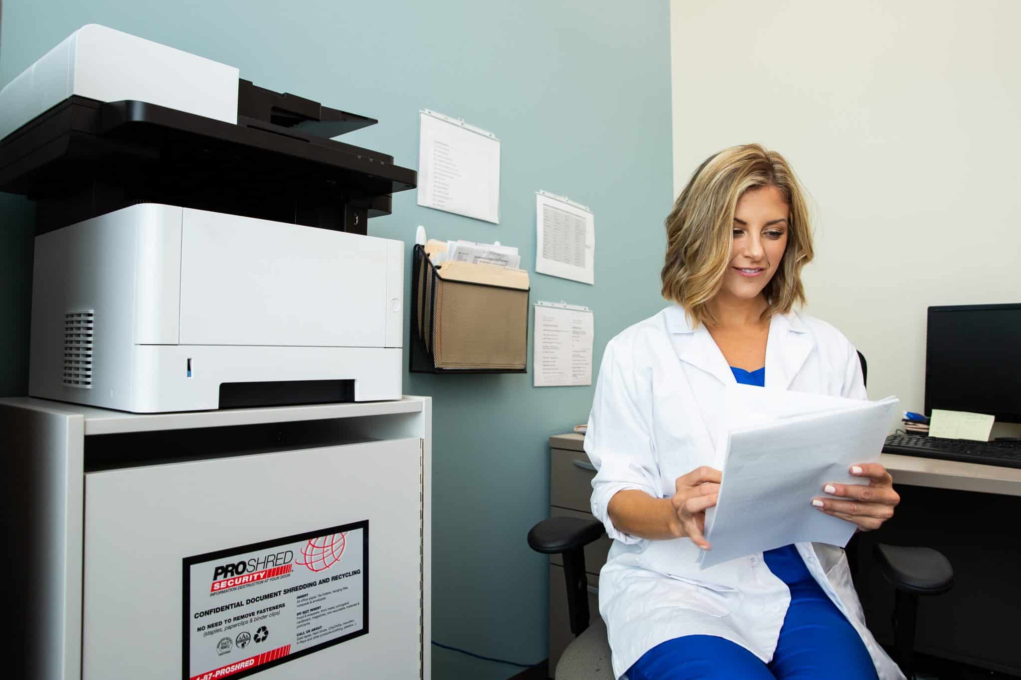 Medical professional reviewing documents in an office.
