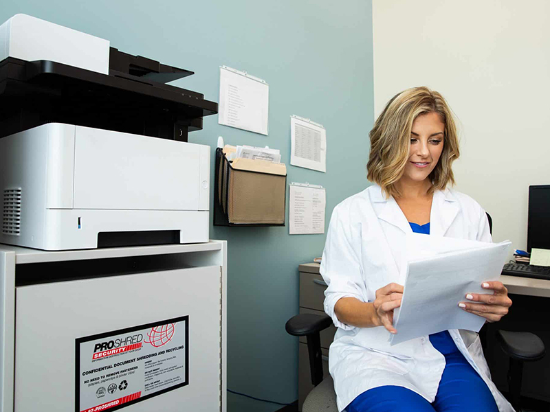 Medical professional reviewing documents in an office.