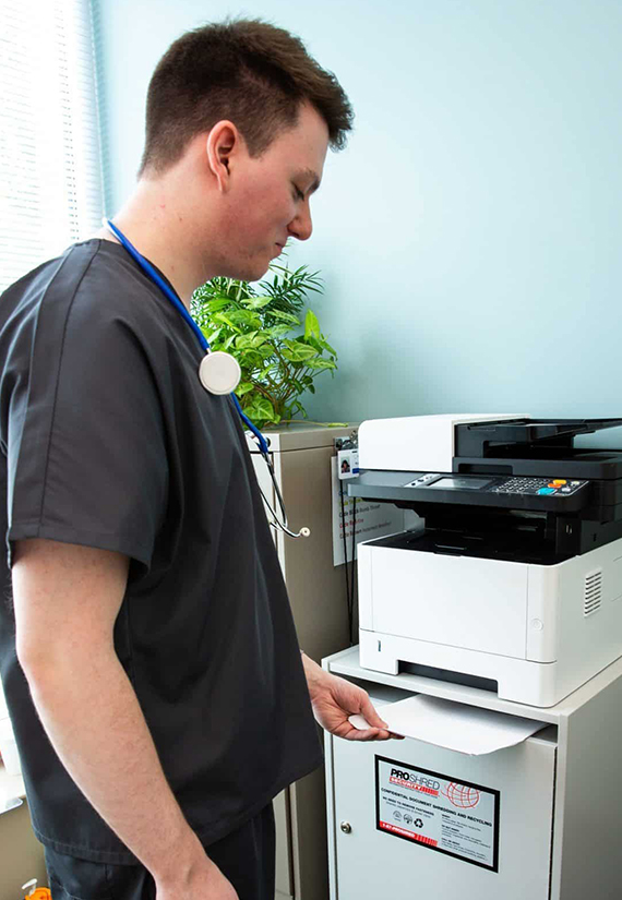Healthcare worker inserting a document near a scanner.
