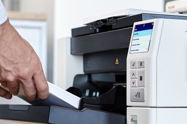 Man scanning documents in a professional scanner