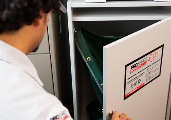 man opening secure paper shredder