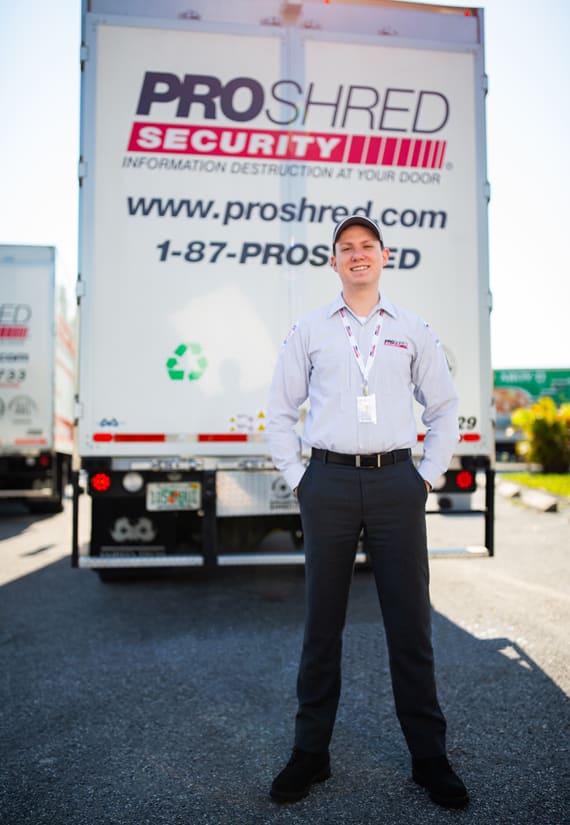 PROSHRED employee standing behind a shredding truck.