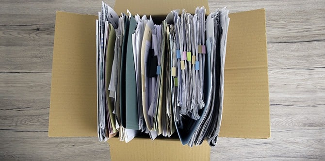 piles of documents containing sensitive information in a box to be transporting to a drop-off PROSHRED location
