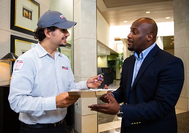 PROSHRED employee going over paperwork with a business professional