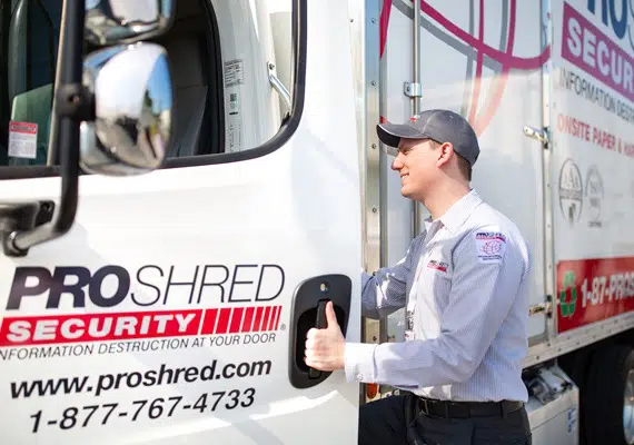 PROSHRED employee getting into a PROSHRED shredding truck