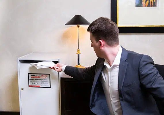 office employee discarding confidential documents into a secure console bin