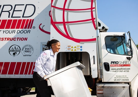 PROSHRED employee with a secure console bin being taken to get shredded by our onsite shredding trucks