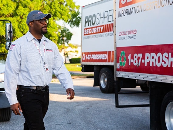 PROSHRED driver beside Proshred shredding trucks