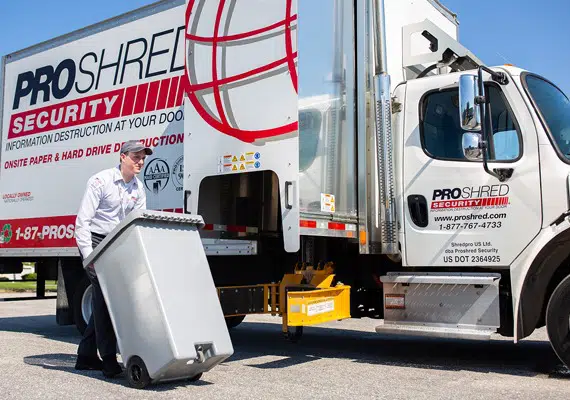 PROSHRED employee with a secure console bin containing confidential documents providing drop-off shredding services