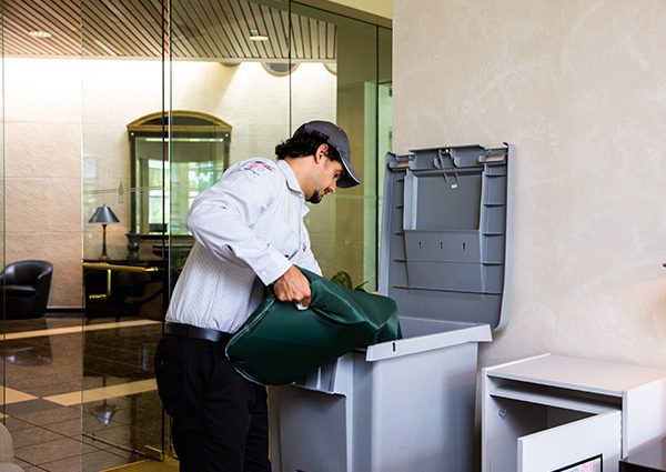 PROSHRED employee with a secure console bin that contains confidential documents