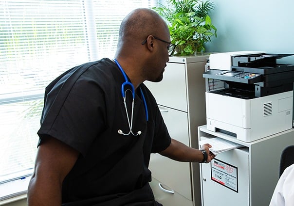 Healthcare professional discarding sensitive information into a secure console bin