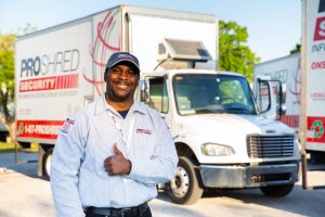 PROSHRED truck driver posed in front of PROSHRED'S shredding trucks