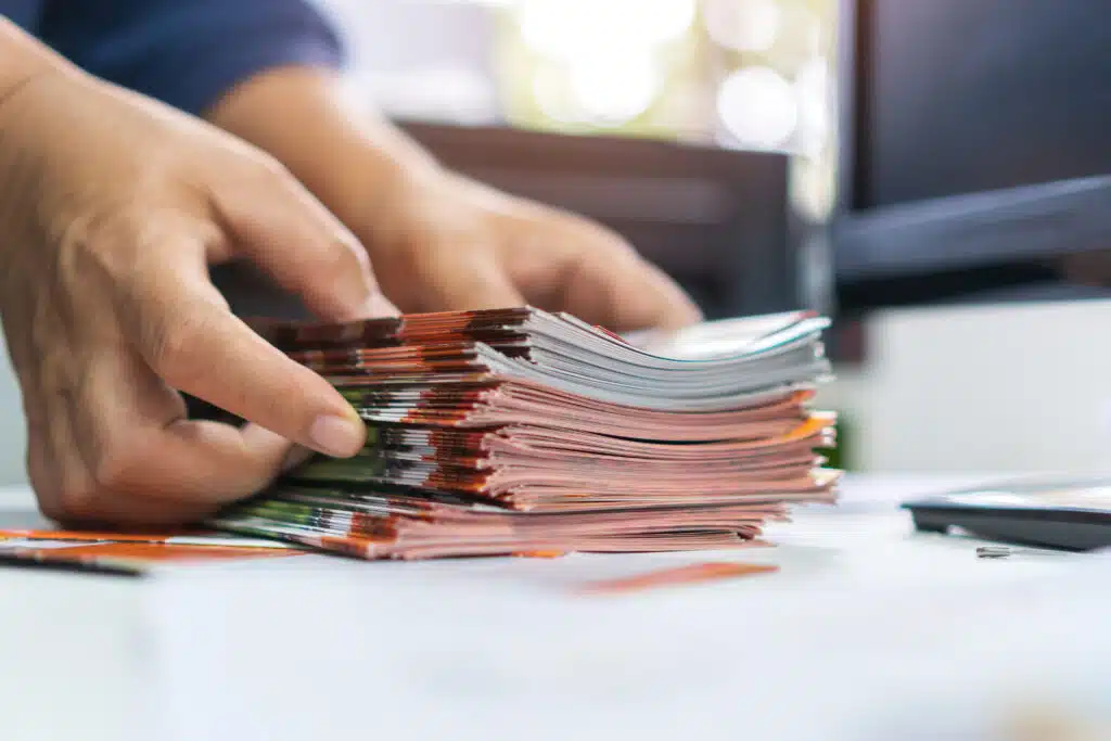 Pile of old brochure document concept : Businessman hands working in business Documents on Stacks Brochures papers files 